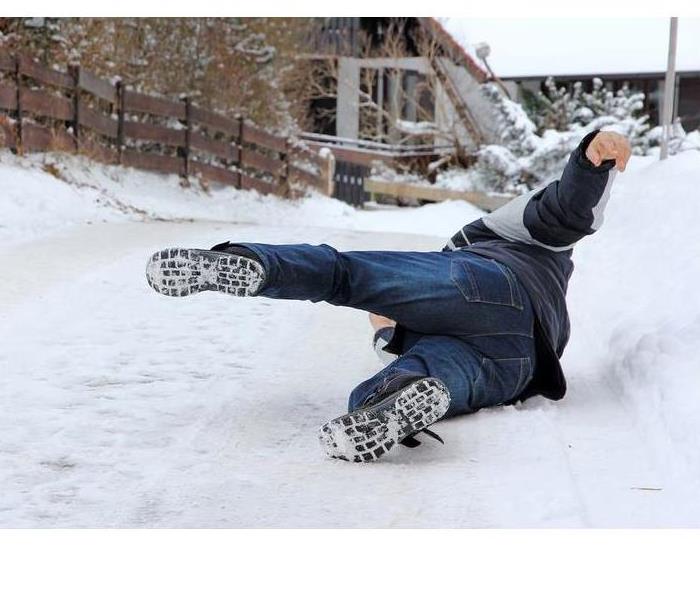 A person slipping on the ice covered ground.