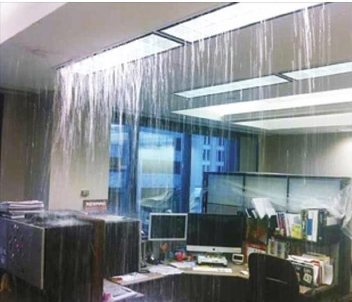 Water pouring from a ceiling in an office.